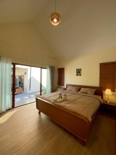 a bedroom with a large bed and a large window at Chortip House in Pai