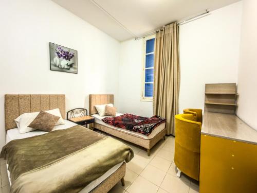 a bedroom with a bed and a chair and a window at Lafayette Central Apartment-Tunis in Tunis