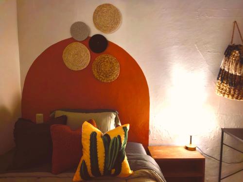 a bedroom with a bed with a red headboard and a lamp at Casa completa en Jalatlaco con cocina equipada y parking hasta 7 huéspedes in Oaxaca City