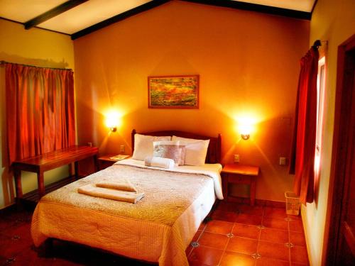 a bedroom with a bed with two lights on at El Encanto Garden Hotel in Santa Cruz