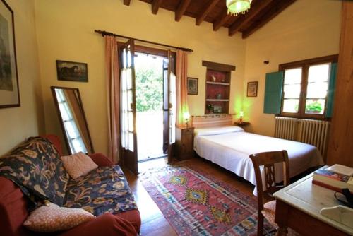 1 dormitorio con cama, sofá y ventana en Casa Rural Iketxe, en Hondarribia