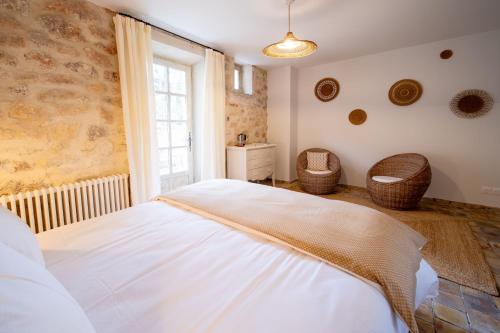 a bedroom with a white bed and a window at Mas Bella Cortis in La Garde-Adhémar
