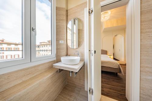 a bathroom with a sink and a bed at Lumi Stays in Florence
