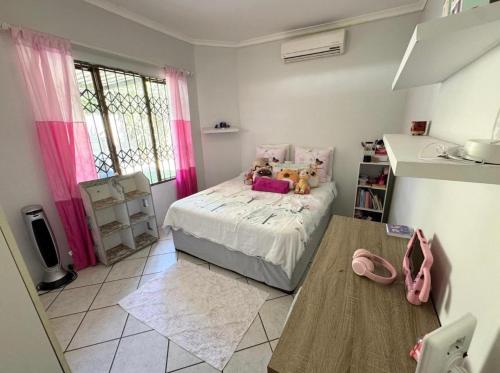 a small bedroom with a bed with stuffed animals on it at One Birdswood in Richards Bay