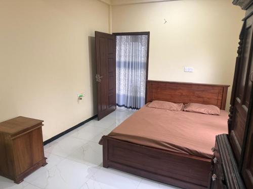 a bedroom with a bed and a dresser in it at Palm Breeze Kokuvil G1 in Jaffna