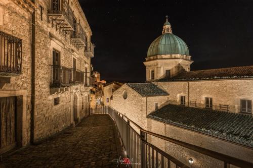 an alley way with a building with a dome on top at Al Centro in Gangi