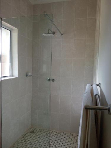 a bathroom with a shower with a glass door at Sani's Rest in Himeville