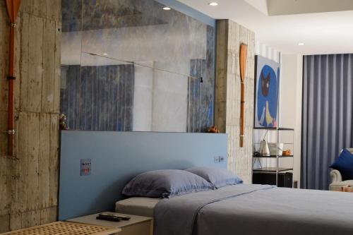 a bedroom with a bed and a painting on the wall at 沐美美藝旅 Mumeimei Artel in Tainan
