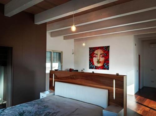 a bedroom with a bed and a painting on the wall at LE SITE in Specchia