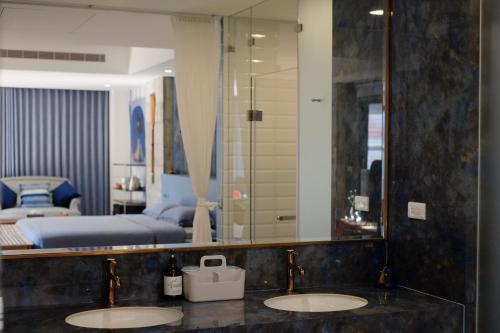 a bathroom with two sinks in front of a bedroom at 沐美美藝旅 Mumeimei Artel in Tainan