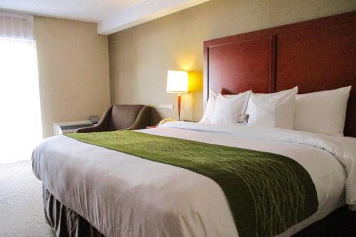 a hotel room with a large bed and a chair at Comfort Inn Dartmouth in Halifax