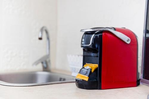 a red suitcase sitting on a counter next to a sink at Ill Balcone sullo stretto in Reggio di Calabria