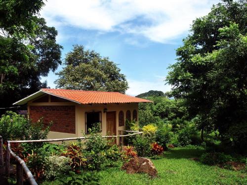 a small house with an orange roof in a yard at El Encanto Garden Hotel in Santa Cruz
