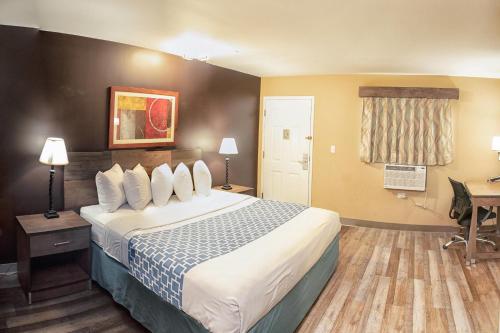 a hotel room with a bed and a desk at Suburban Studios Charlotte - Ballantyne in Charlotte