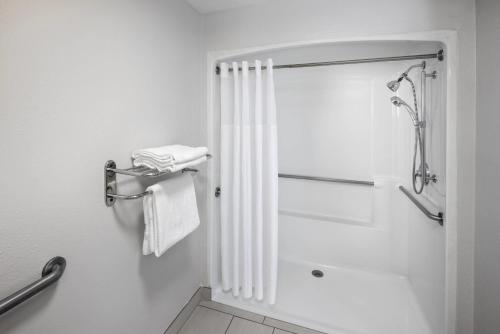 a bathroom with a shower with a shower curtain at Clarion Pointe Biltmore Village in Asheville