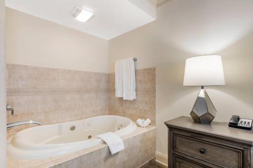 a bathroom with a tub and a lamp on a counter at Clarion Hotel & Conference Center Toms River in Toms River