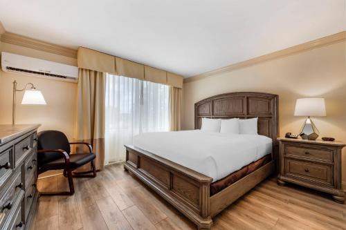 a bedroom with a bed and a desk and a chair at Clarion Hotel & Conference Center Toms River in Toms River