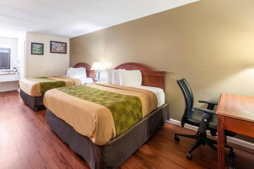 a hotel room with two beds and a desk at Econo Lodge Franklin - Springboro in Franklin