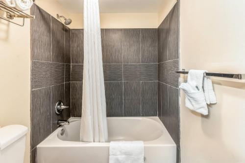 a bathroom with a white tub and a toilet at Econo Lodge Franklin - Springboro in Franklin