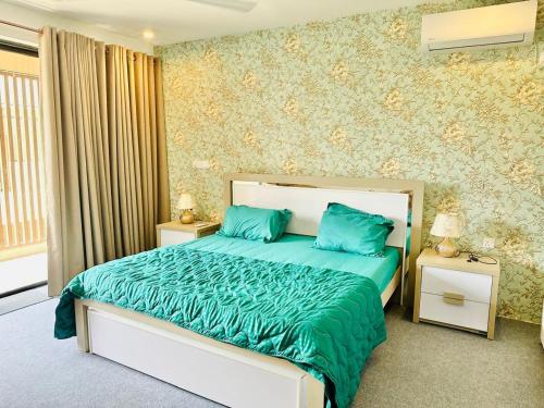 a bedroom with a bed with blue pillows on it at Sea esta villa in Mount Lavinia