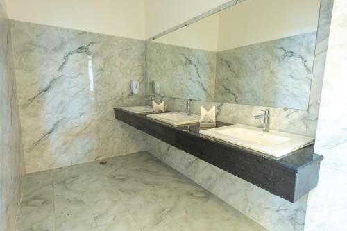 a bathroom with two sinks and a mirror at Hotel Annapurna The Luxurious in Nalanda