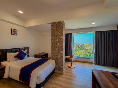 a hotel room with a bed and a large window at Zip By Spree Hotels Ranjangaon in Ranjangaon Ganpati