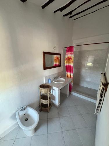 a bathroom with a toilet and a sink at Blue House Watamu in Watamu