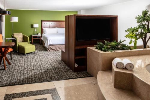 a hotel room with a bed and a television at Holiday Inn Mexico City - Trade Center by IHG in Mexico City
