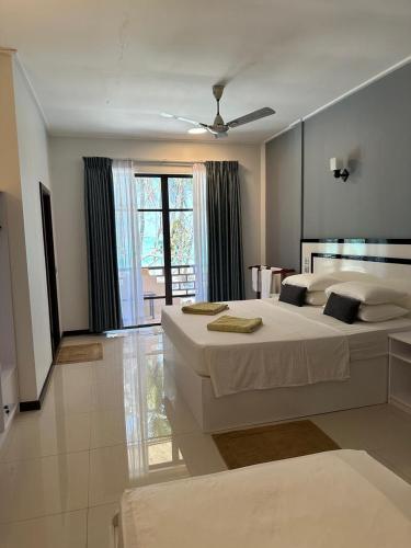 a bedroom with two beds and a ceiling fan at Riveli Retreat Mathiveri in Mathiveri