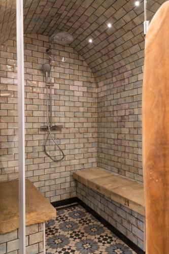 a bathroom with a shower in a brick wall at ETHOS Bertolina Wellness Urban Living in Albufeira
