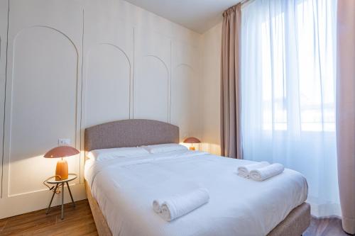 a bedroom with a white bed with two towels on it at Lumi Stays in Florence