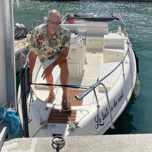 a man sitting on a boat in the water at Le Bateau du Canal Sète in La Celle-sous-Gouzon