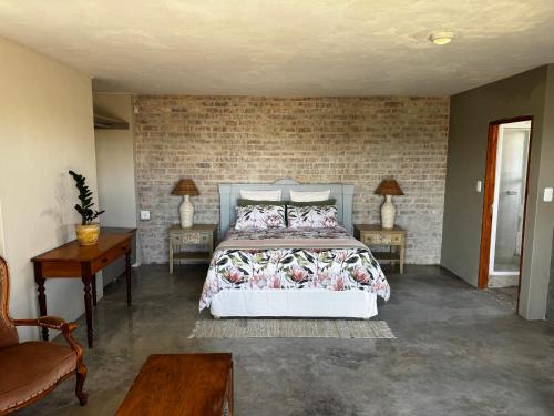 a bedroom with a bed and two chairs and a table at Fraai Brak in Klein-Brakrivier