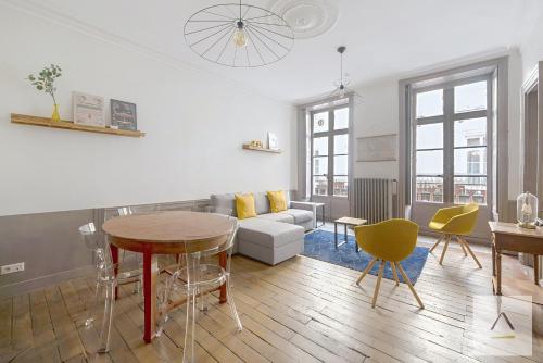 a living room with a couch and a table and chairs at L'Historique in Rennes