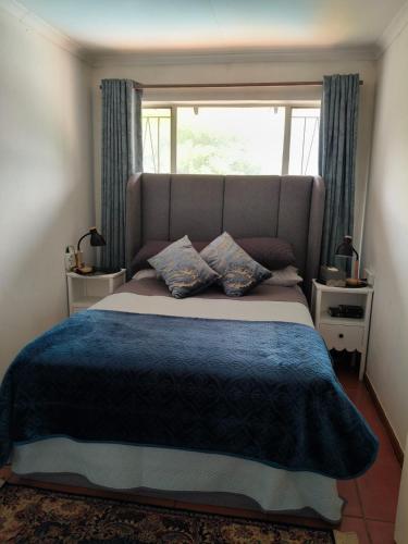 a bedroom with a large bed with a window at Loema-in in Roodepoort