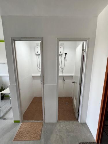 a bathroom with two stalls and two mirrors at Matropica CoWorking Hostel in General Luna