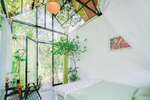 a room with a table and a large window at MOCAY farmstay in Ben Tre