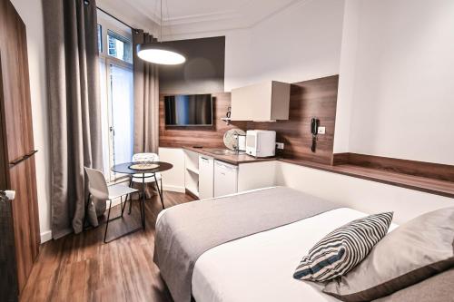 a hotel room with a bed and a small kitchen at Les cles du 27 Paris in Paris