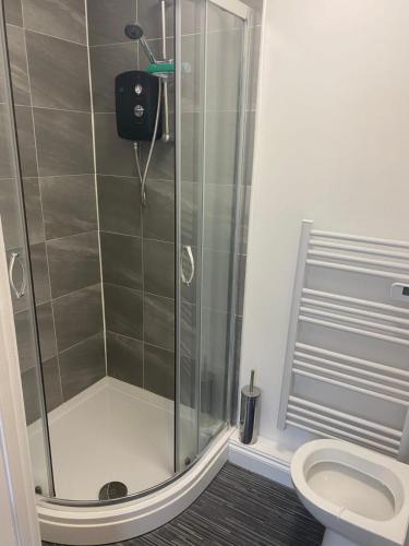 a shower stall in a bathroom with a toilet at Beresford Guest House in Stoke on Trent