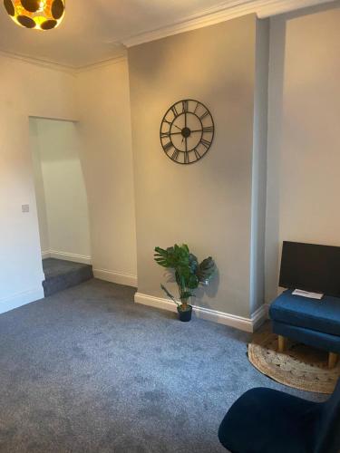 a room with a clock on the wall and a plant at Beresford Guest House in Stoke on Trent