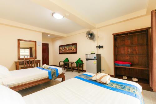 a hotel room with two beds and a refrigerator at SK House 2 in Chiang Mai