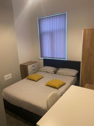 a small bedroom with two beds and a window at Beresford Guest House in Stoke on Trent