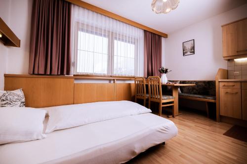 a bedroom with two beds and a desk and a window at Appartement Susanna in Fügen