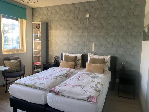 two twin beds in a room with a wall at B&B De Domburcht in Domburg