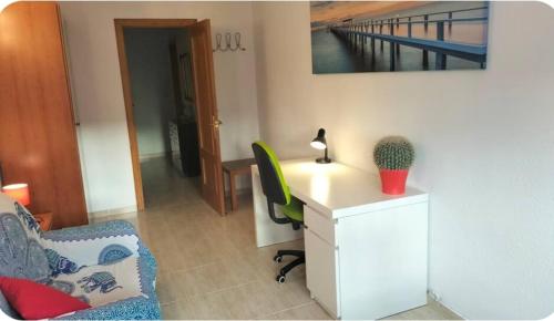 a room with a desk and a chair with a computer at Habitación individual en la playa in Alicante