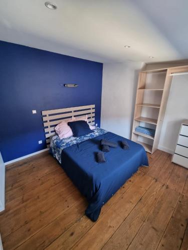 a blue bedroom with a bed with a blue wall at Le Duplex in Coligny