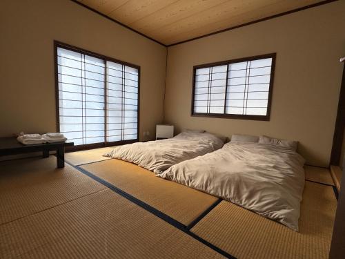 a bedroom with two beds and two windows at Fuji-Kurohime- in Shinano