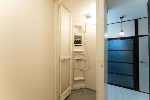 a bathroom with a walk in shower next to a door at JPtrad 葵 なんばや心斎橋にも直結の8名様まで宿泊可能の広々メゾネット in Osaka