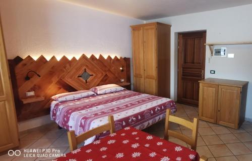 a bedroom with a bed and a wooden headboard at Monolocale Belvedere in La Thuile