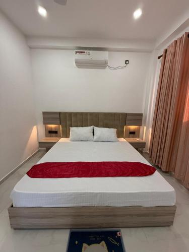 a bedroom with a bed with a red blanket on it at Southern Hight's Villa in Unawatuna